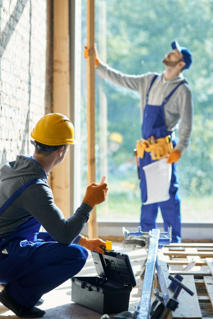 Renovate your house. Young male engineer working at cottage construction site, picking instrument